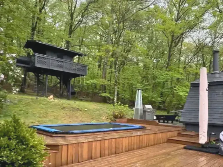 Backyard with a deck, trampoline, and treehouse in West Milford, NJ.