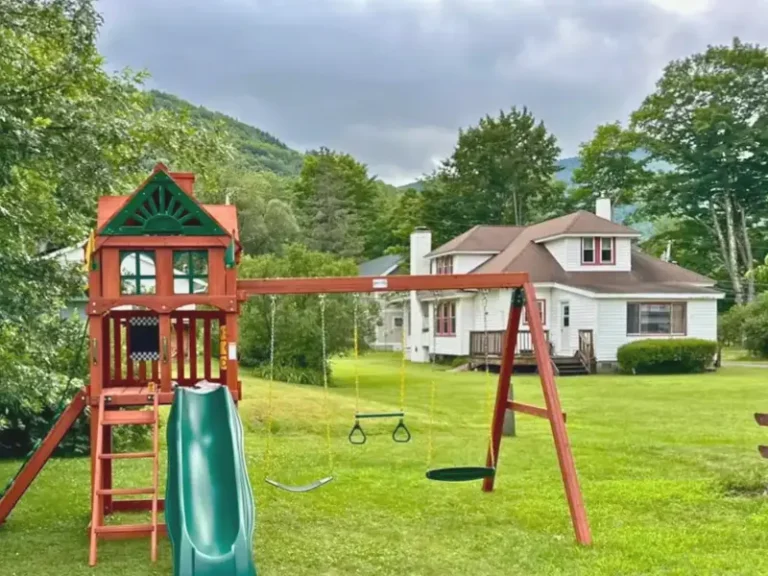 Backyard playset with a slide and swings in Lanesville, NY.