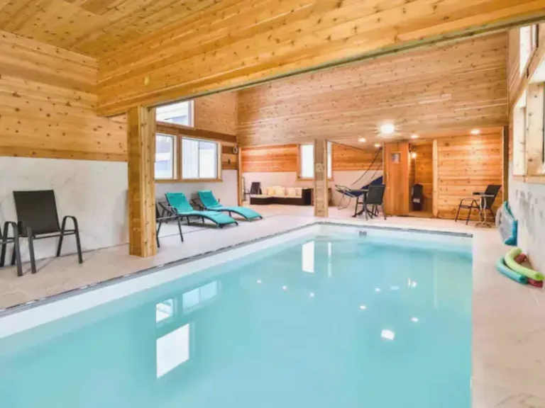 Indoor pool with lounge chairs and a game area in Lanesville, NY Airbnb.
