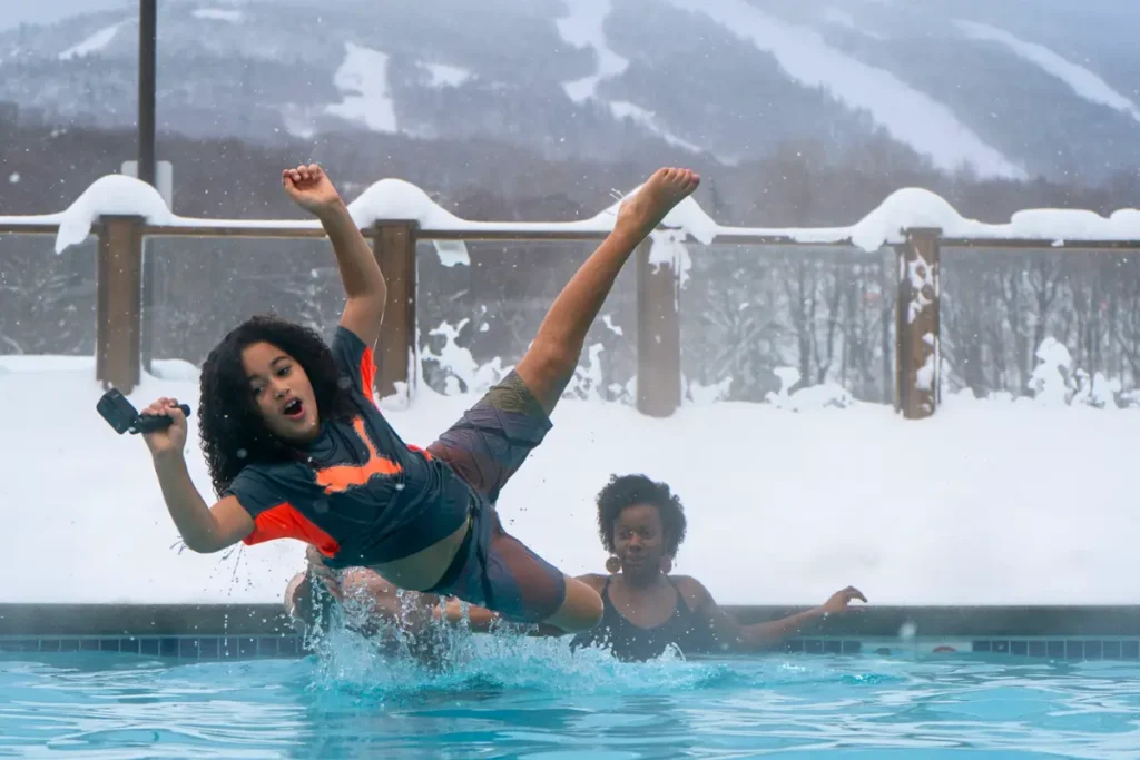 Kids splashing in one of Killington Grand Resort’s outdoor pools in winter.