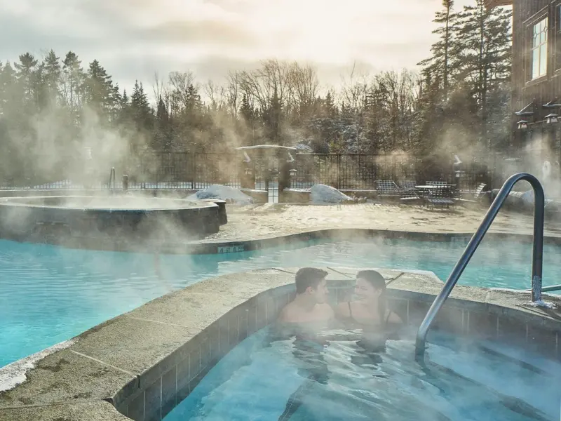 Steaming outdoor pool at Whiteface Lodge in Lake Placid during winter.