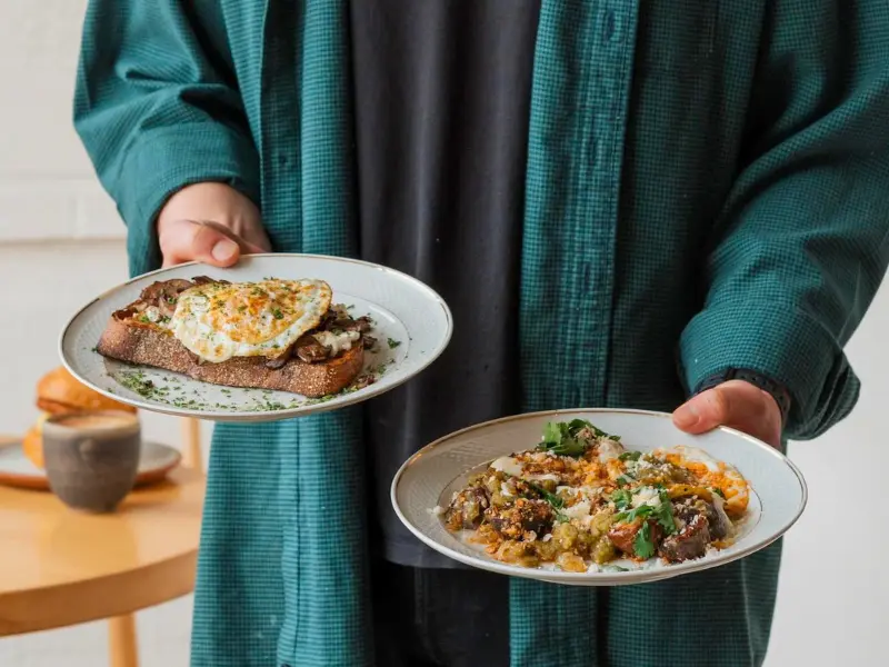 Breakfast plates at Nana’s Mystic with egg-topped toast and seasonal veggie hash