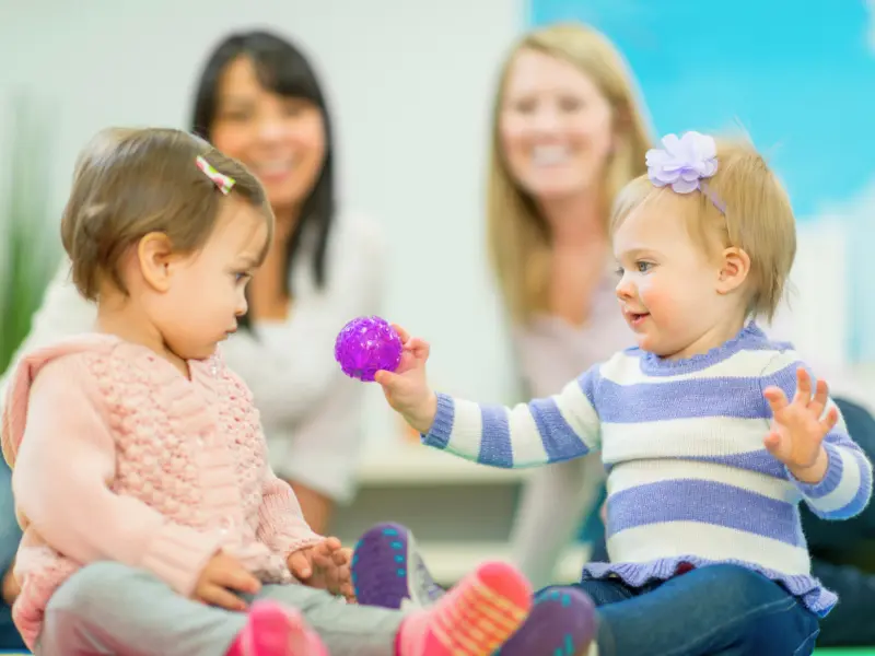 Two toddlers playing with a toy at a Children's Museum