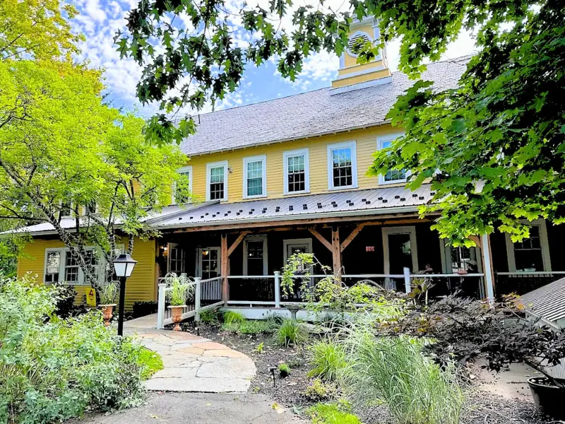 The Old Mill Inn in Hatfield Massachusetts with garden path and yellow exterior.