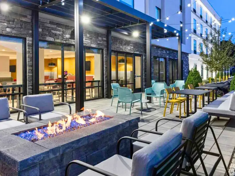 Outdoor patio with firepit and string lights at Home2 Suites East Haven.
