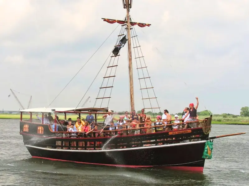 Pirate-themed boat cruise with kids on deck firing water cannons.