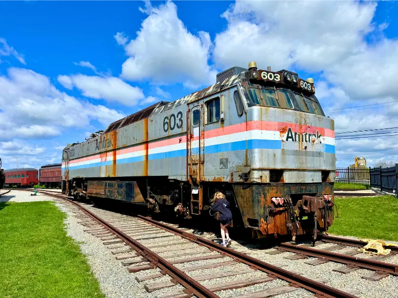 Child climbing on rusted Amtrak train engine in Strasburg PA.