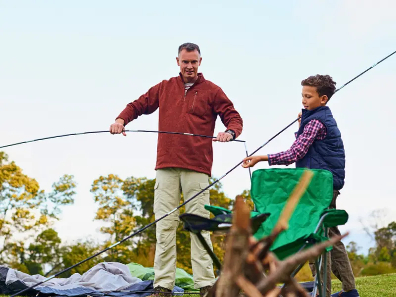 Dad and son assembling a camping tent