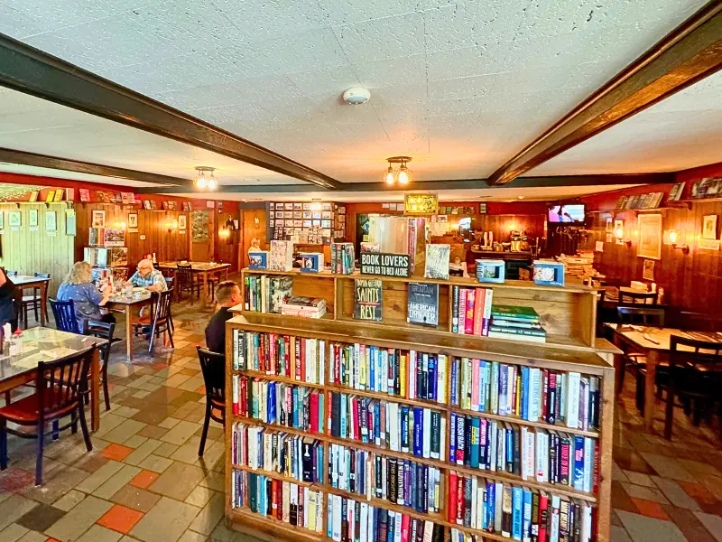 Bookshelves and dining tables inside The Traveler Restaurant in Connecticut.