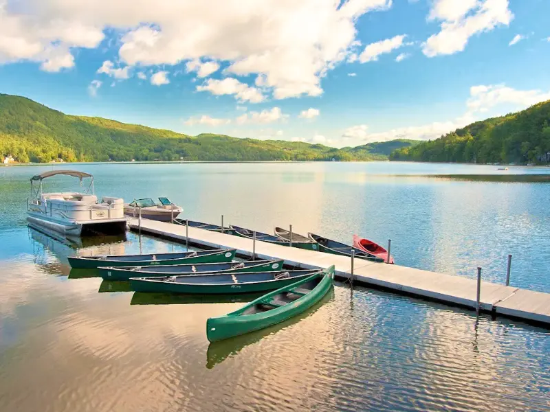 Canoes and pontoon boats docked on Lake Morey in Fairlee, VT