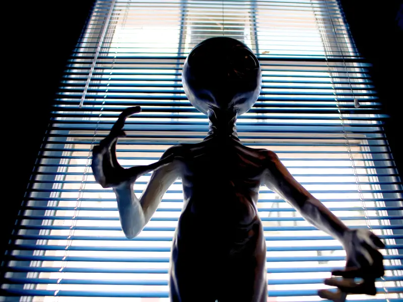 Alien figure in a dimly lit room at a weird UFO and Paranormal museum.