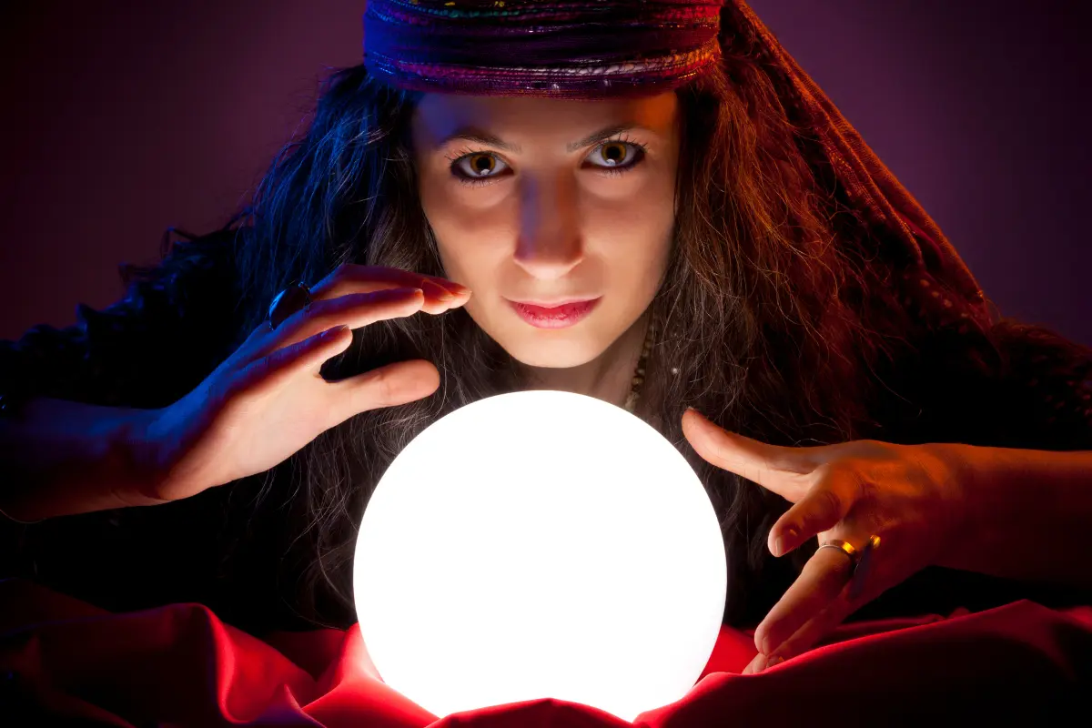 Woman with a glowing crystal ball at a spooky museum attraction.
