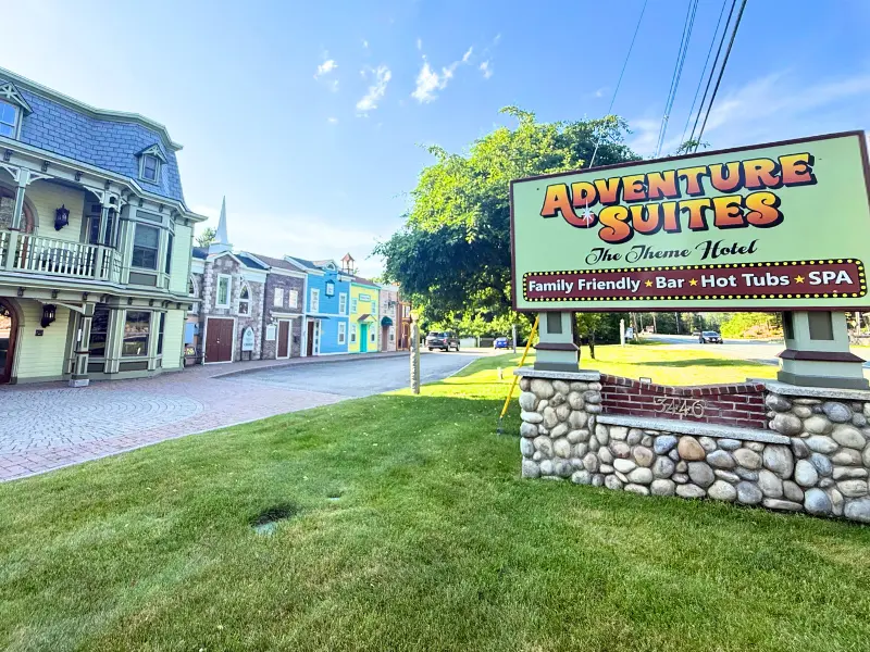 Entrance sign and colorful western-style buildings at Adventure Suites in New Hampshire.