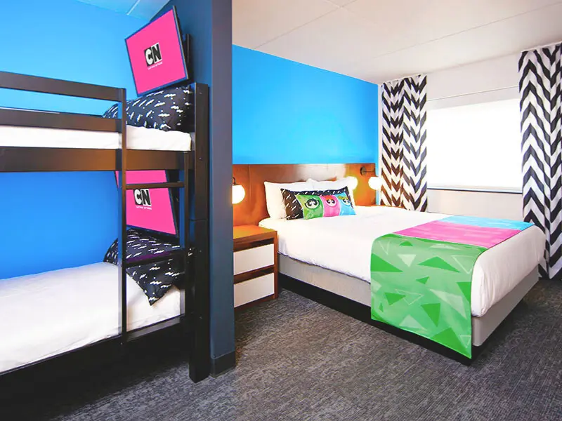 Colorful Cartoon Network themed hotel room with bunk beds and bright bedding