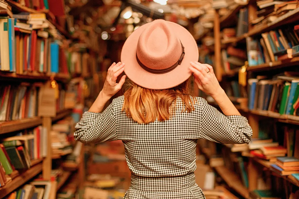 Woman browsing the shelves in a narrow used bookstore