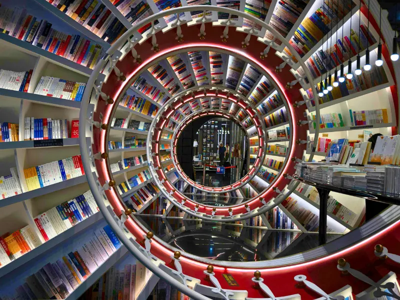 Futuristic spiral bookstore with curved shelves and mirrored tunnel of books