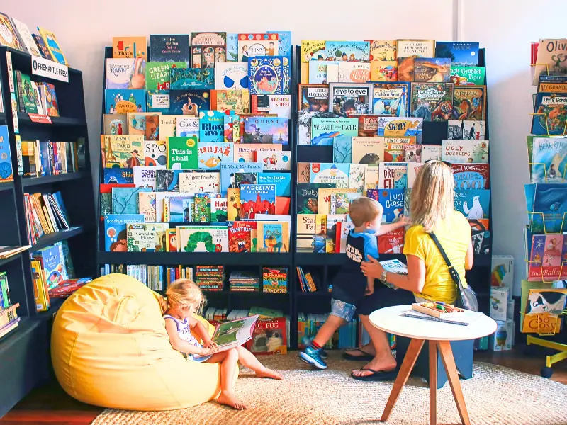 Mom and two kids reading in a colorful children’s bookstore, a bright stop for Book Lovers