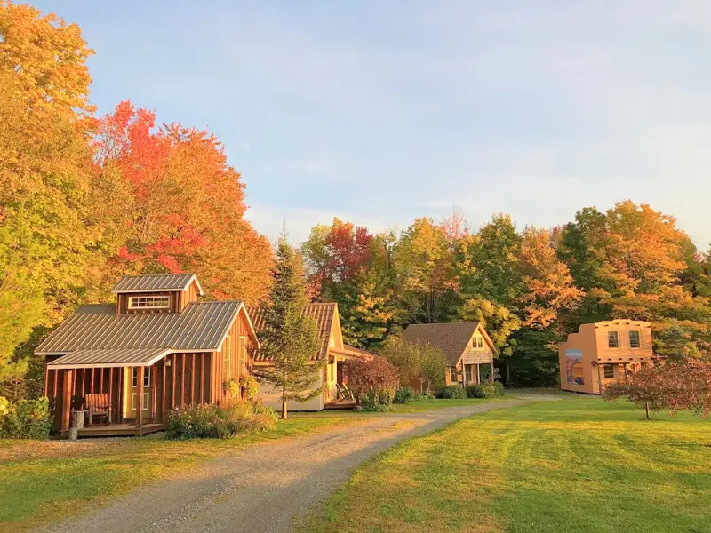Row of tiny themed cottages surrounded by Vermont fall foliage at Crofter’s Green.