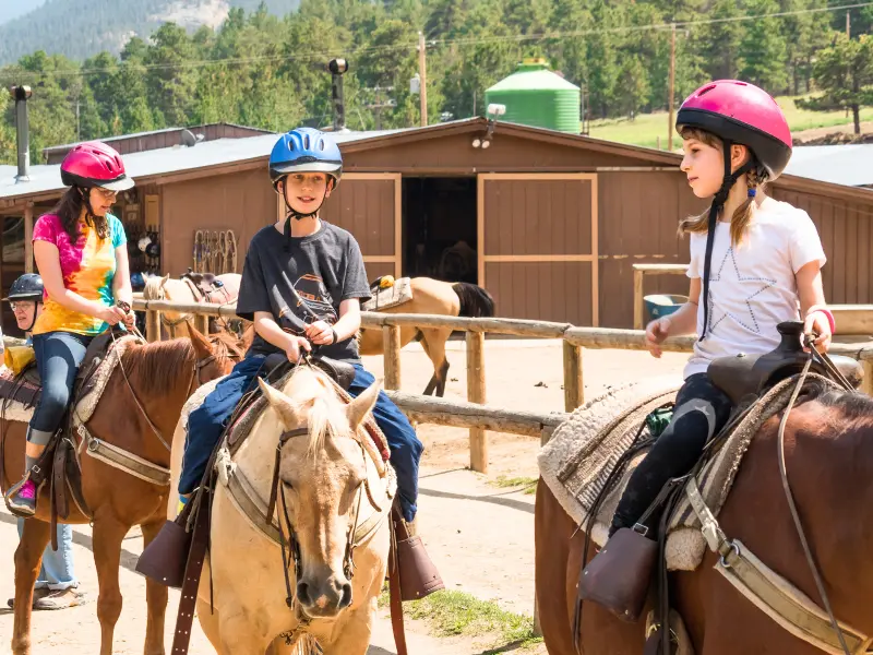 Kids saddling up for a trail ride at a horseback riding family vacation resort