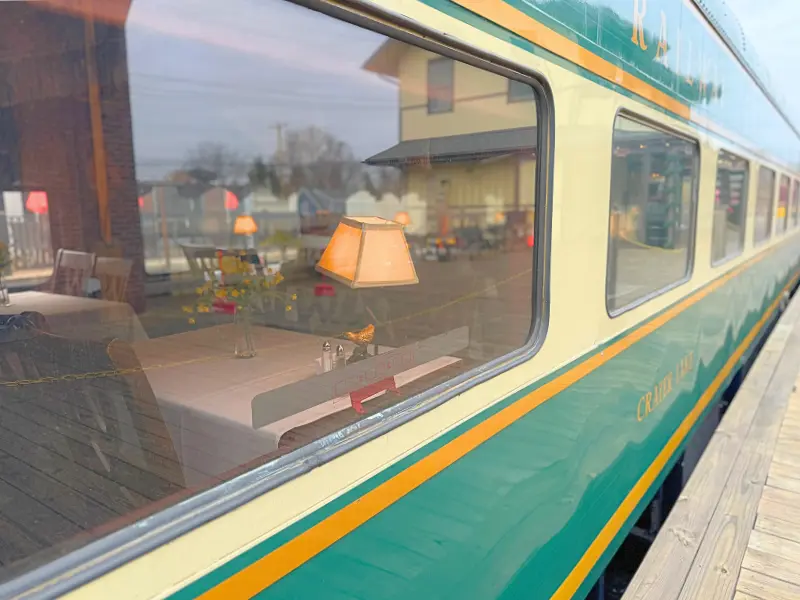 Green New Hope Railroad dining car with tables and lamps visible through the window.