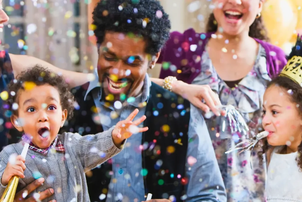 Kids and parents celebrating with confetti and party blowers