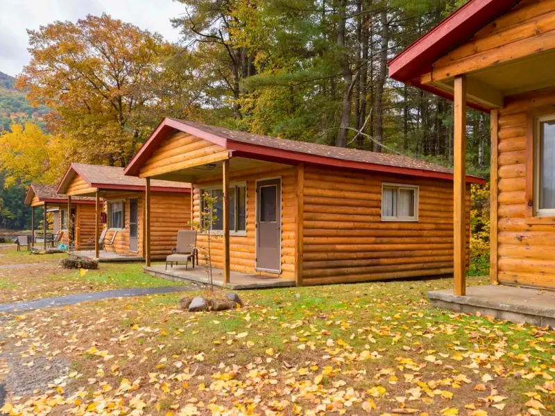 Log cabin exteriors at 1000 Acres Ranch in Stony Creek NY during fall
