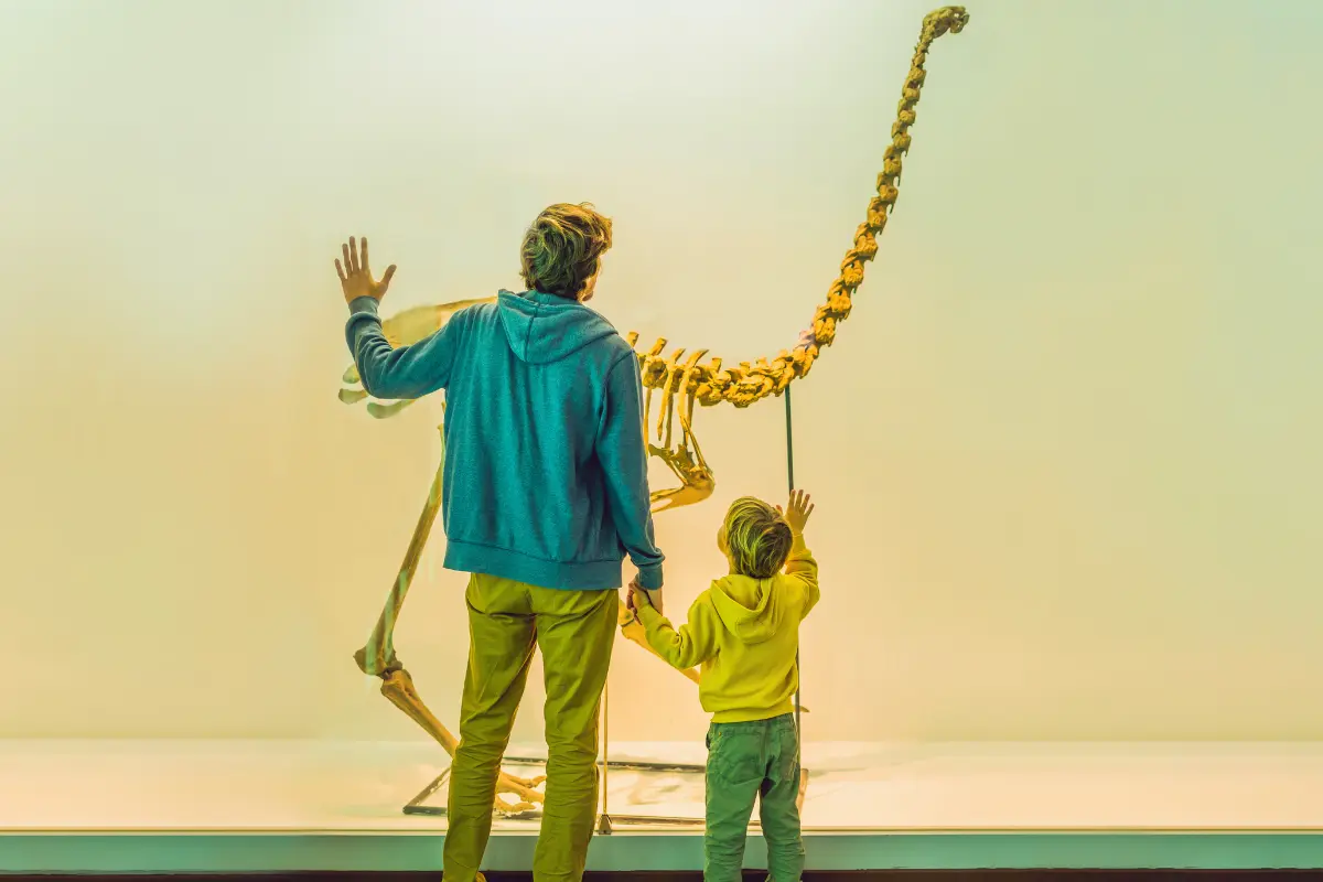 Dad and son waving at a dinosaur skeleton exhibit at one of the free museums in Connecticut