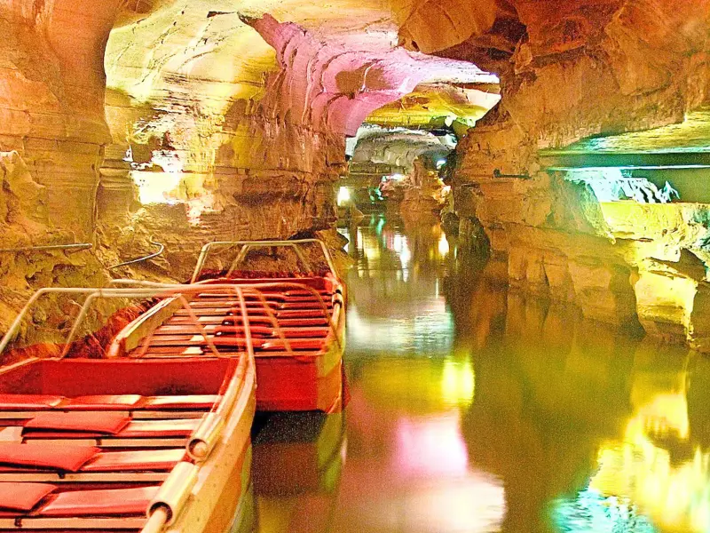 Boat tour through illuminated cave passage at Howe Caverns in Howes Cave, New York