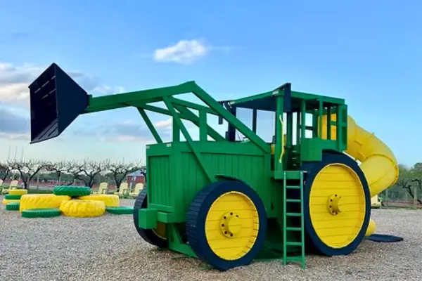 Large green tractor playground with slide at Lookout Farm in South Natick on gravel play area